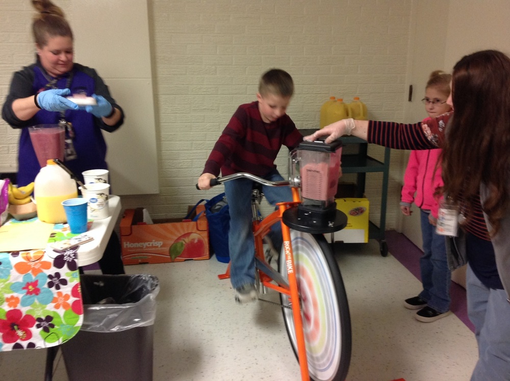 1st grader making a smoothie on the smoothie bike.