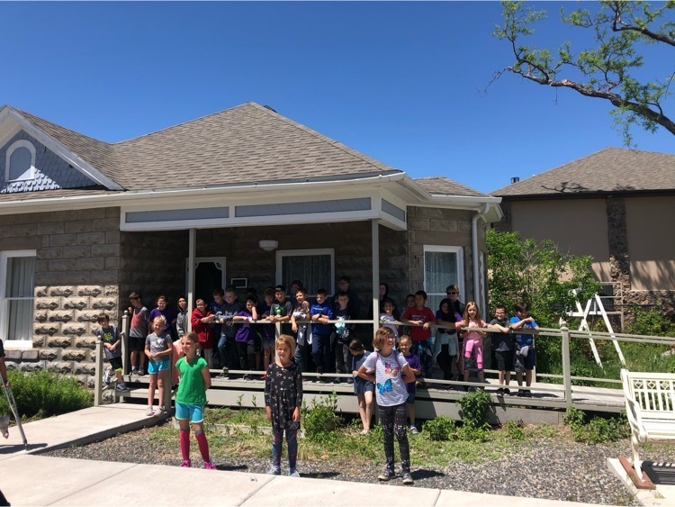 Group photo in front of a typical home from that time period