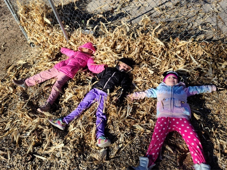 children playing in corn husk pile